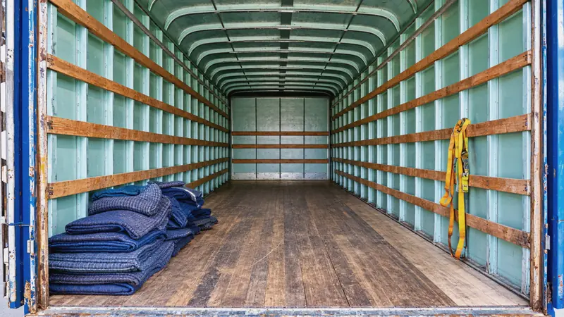 Inside a truck box, with moving blankets and straps to secure the load