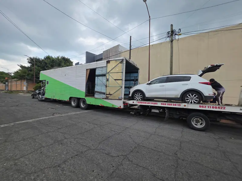 Express Rico truck next to a tow truck carrying a white SUV