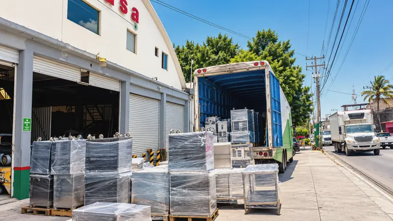 Shrink-wrapped furniture and items on pallets, ready to load